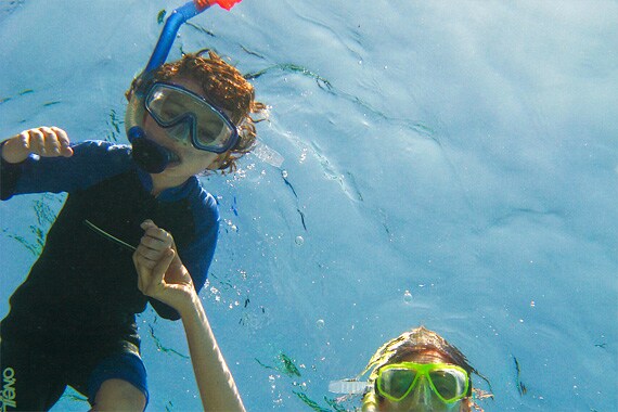 All ages enjoy snorkeling the beautiful coral patches from the western beach of Half Moon Caye.