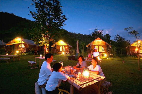 Enjoy a delicious Thai dinner at an open-air restaurant in Kanchanaburi.