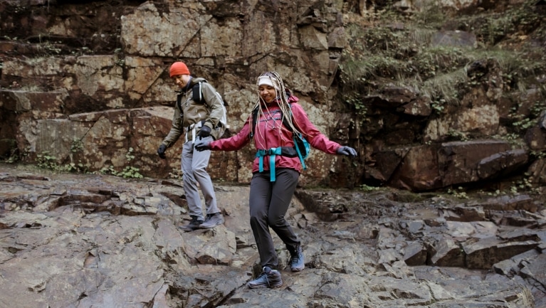 Two people hike over rocky terrain