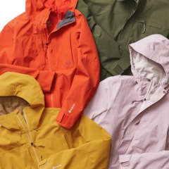A close-up of the intersection of four R E I Co-op brand snow jackets laid out flat and slightly overlapping.