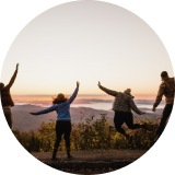 4 people jumping in the air at sunset