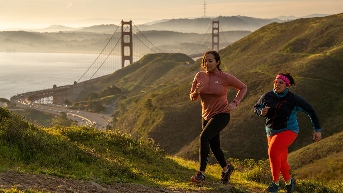 two people jogging up a hill near Golden Gate bridge