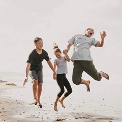 A family cavorts on a beach