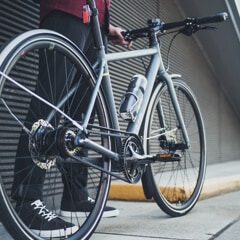 A person stands next to a bike