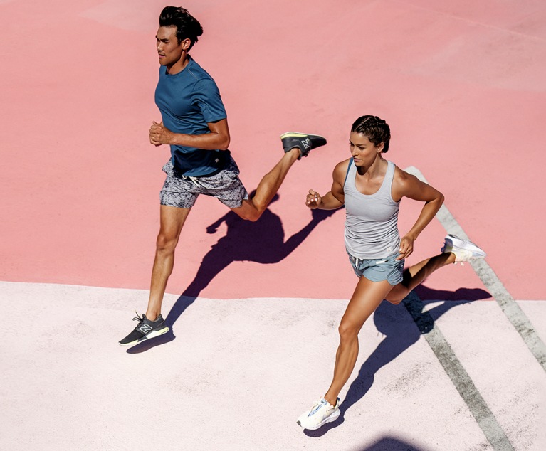 Two runners in fitness attire jog on concrete on a sunny day.