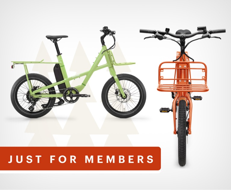 Two R E I Co-op electric bikes. Text reads, just for members.