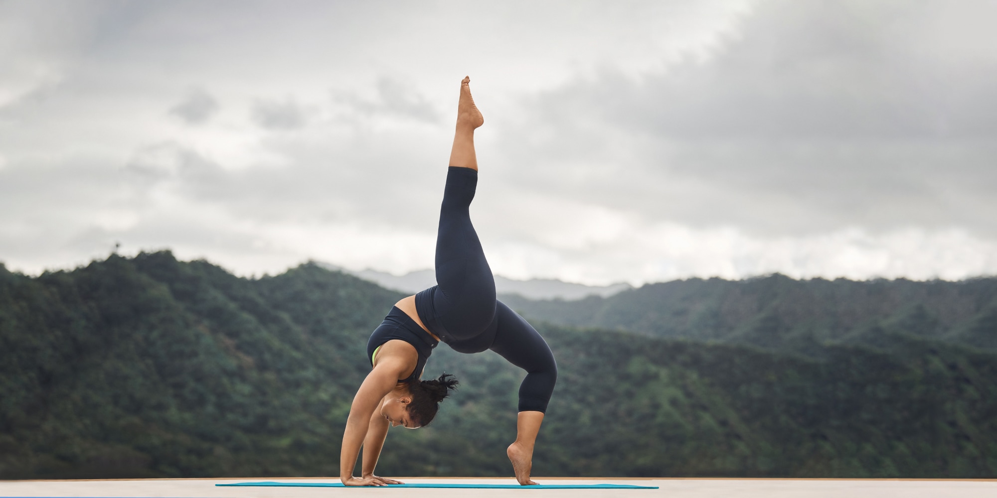 A person stretches in front of a mountain range