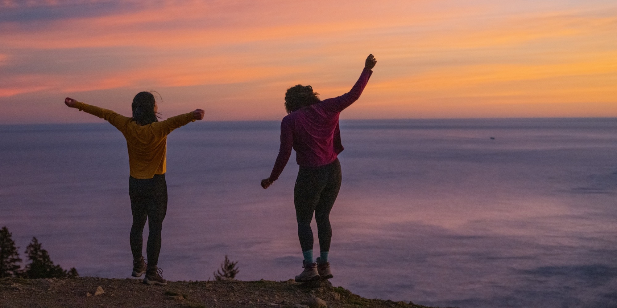 Two hikers enjoy a sunset