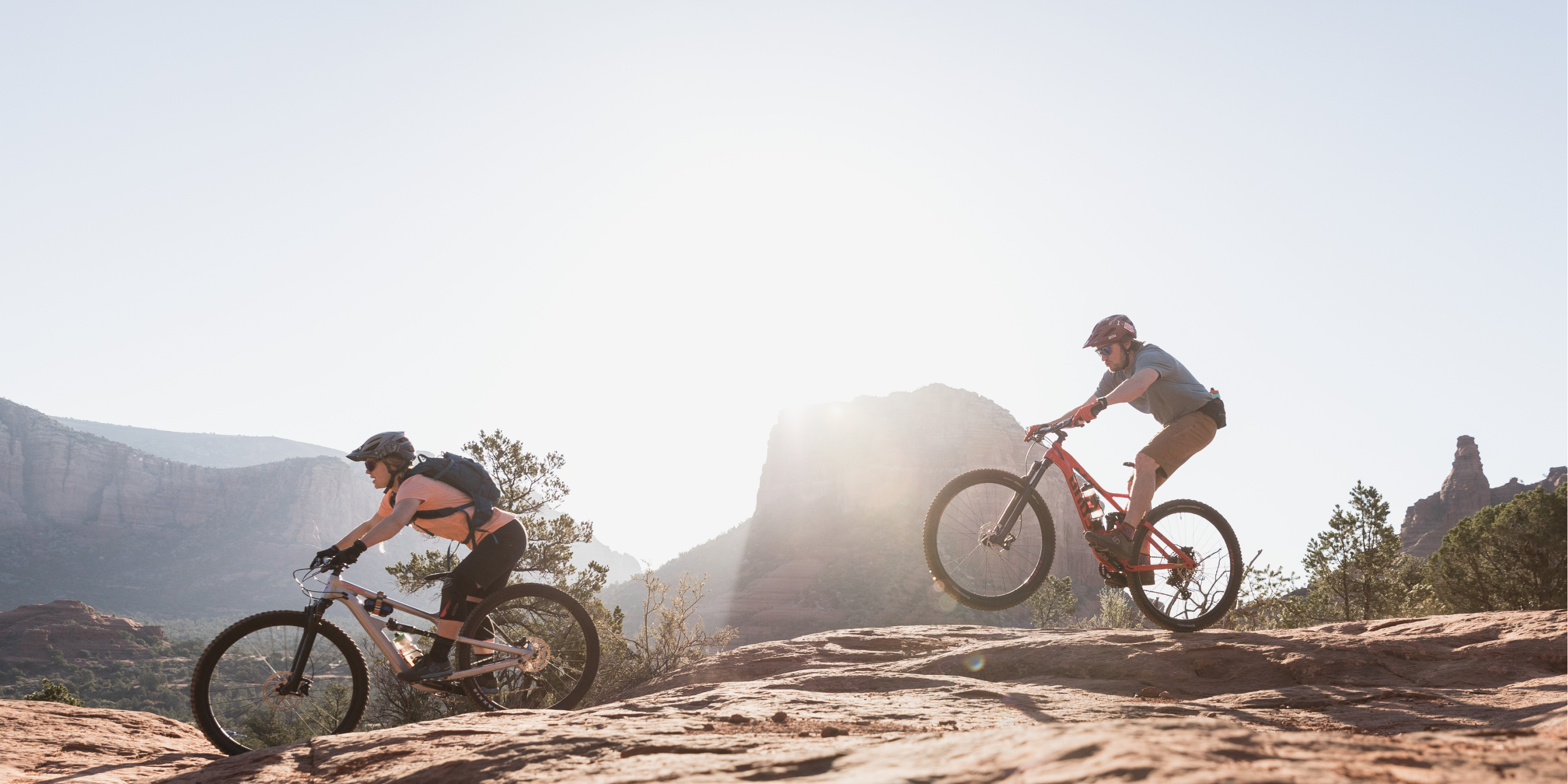 A group of mountain bikers ride on a sunny day. Text reads Spring Savings.