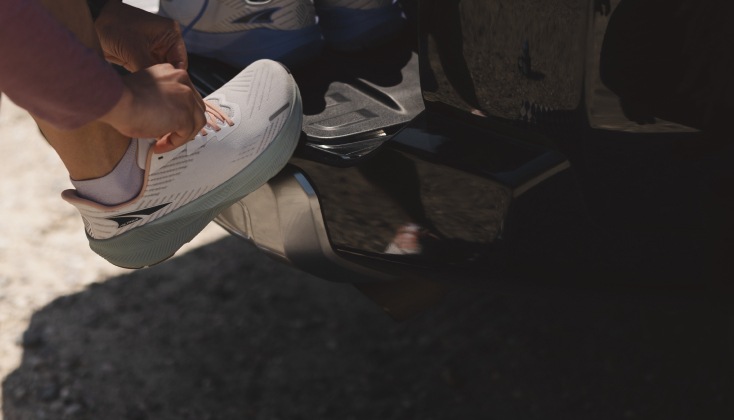 A person lacing up the new Altra F W D running shoe.