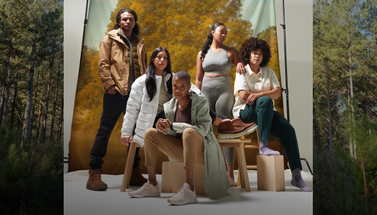 A group of people modeling recreational clothing in a photo studio with nature photography backdrops.