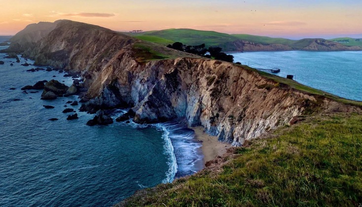 A cliff-side cove at dawn. Text reads, co-op experiences.