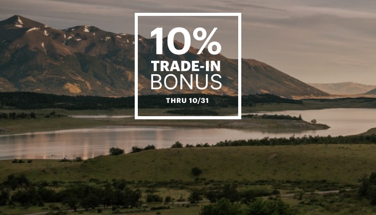 A lake with a mountain backdrop. Text reads, 10 percent trade-in bonus through October 31.