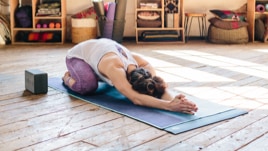 On a yoga mat in their serene studio, a solitary figure breathes through a child's pose.