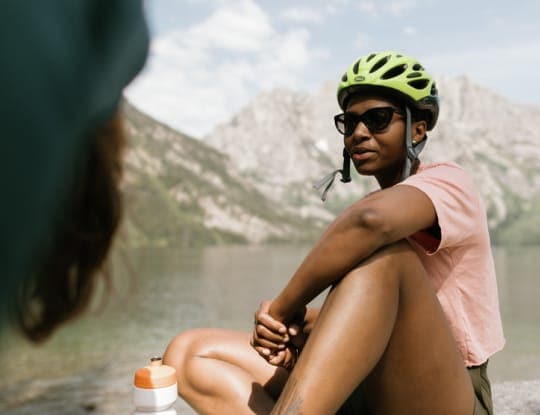A cyclist cools off near the water's edge