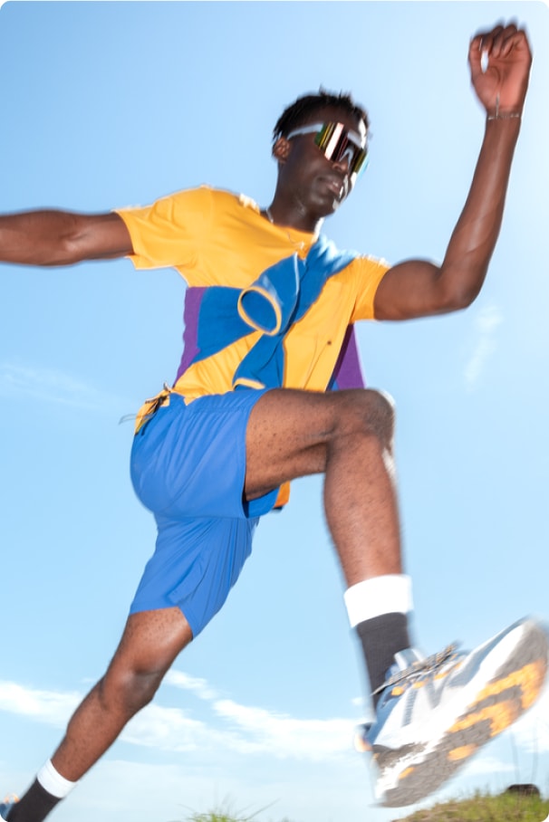 A person jumping, wearing the Outdoor Afro Incorporated and R E I Co-op collection.