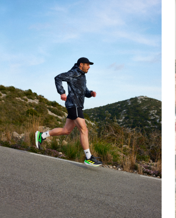 A runner jogs downhill on an outdoor trail.
