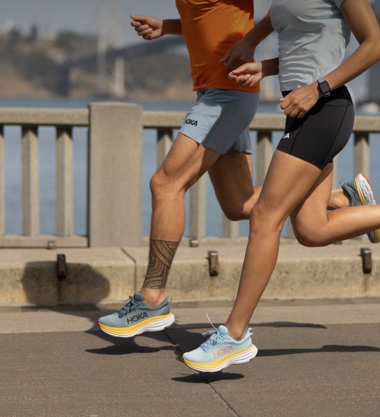 A tightly cropped shot of Hoka shoes worn by runners in motion.