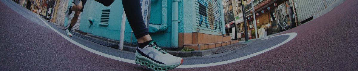 A fish-eye shot of runners' feet in On shoes.