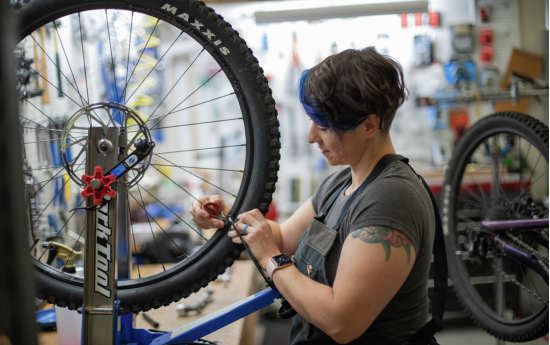 A bike technician makes repairs on a bike tire
