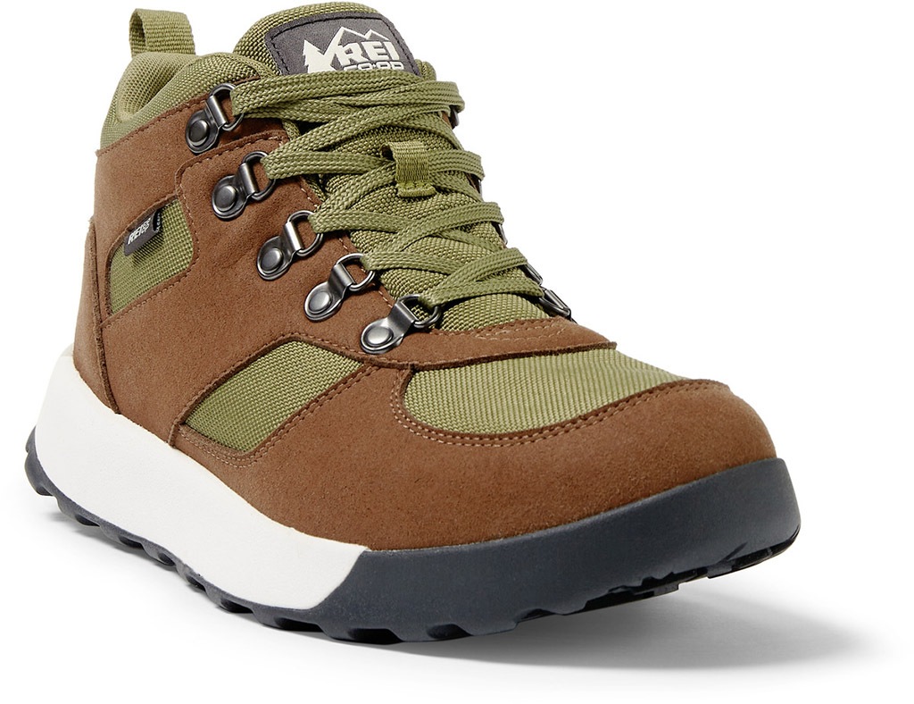 A dark brown and olive colored hiking boot against a white background