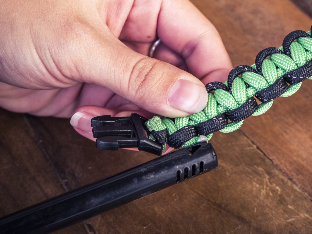 Paracord strand end with a lighter after gluing melted chord down