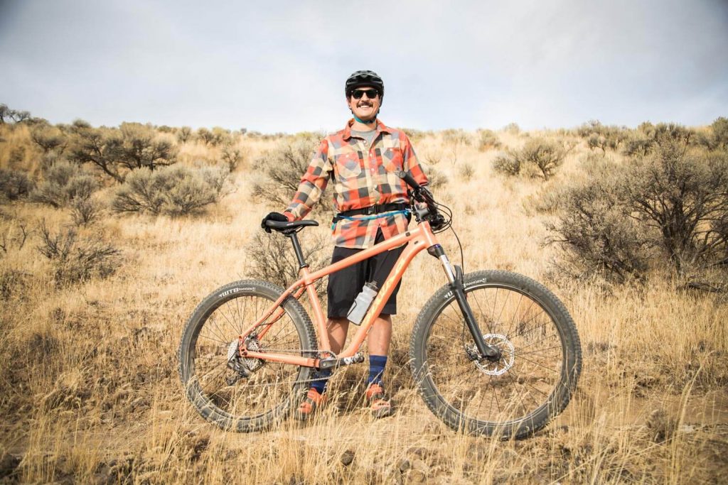 Rider standing behind his bike.