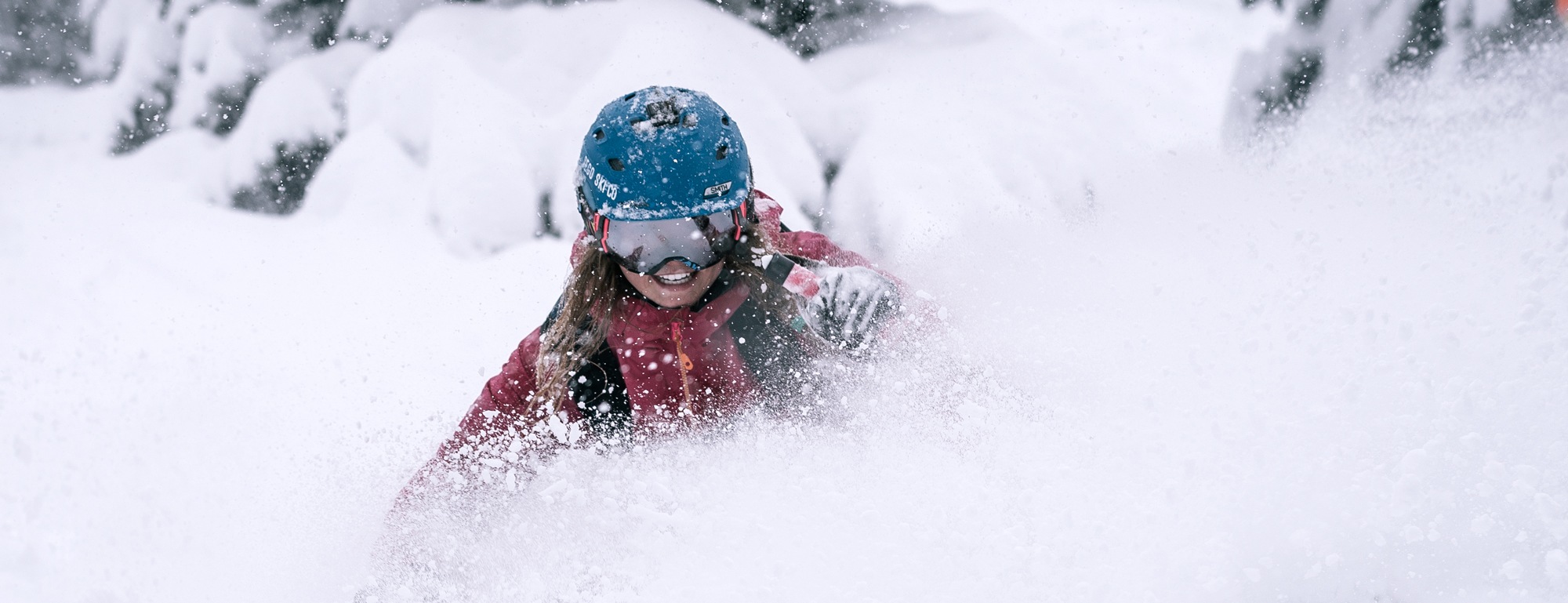 A woman skis in deep powder snow.