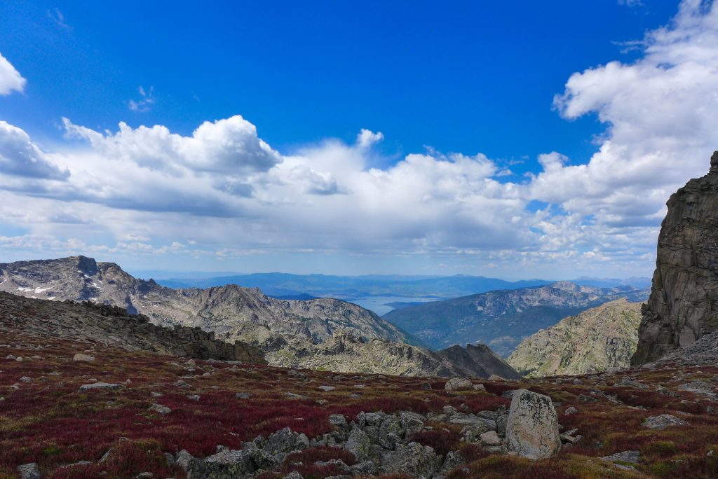A lake in the valley below a rocky mountainous landscape.