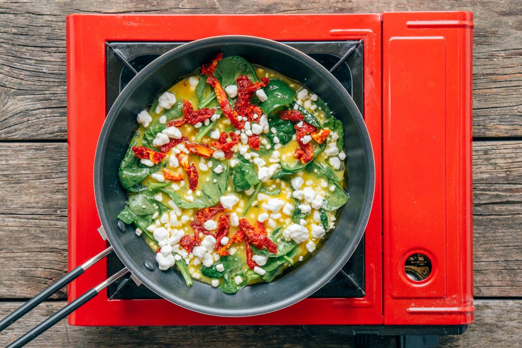 Spinach frittata ingredients in pan and cooking