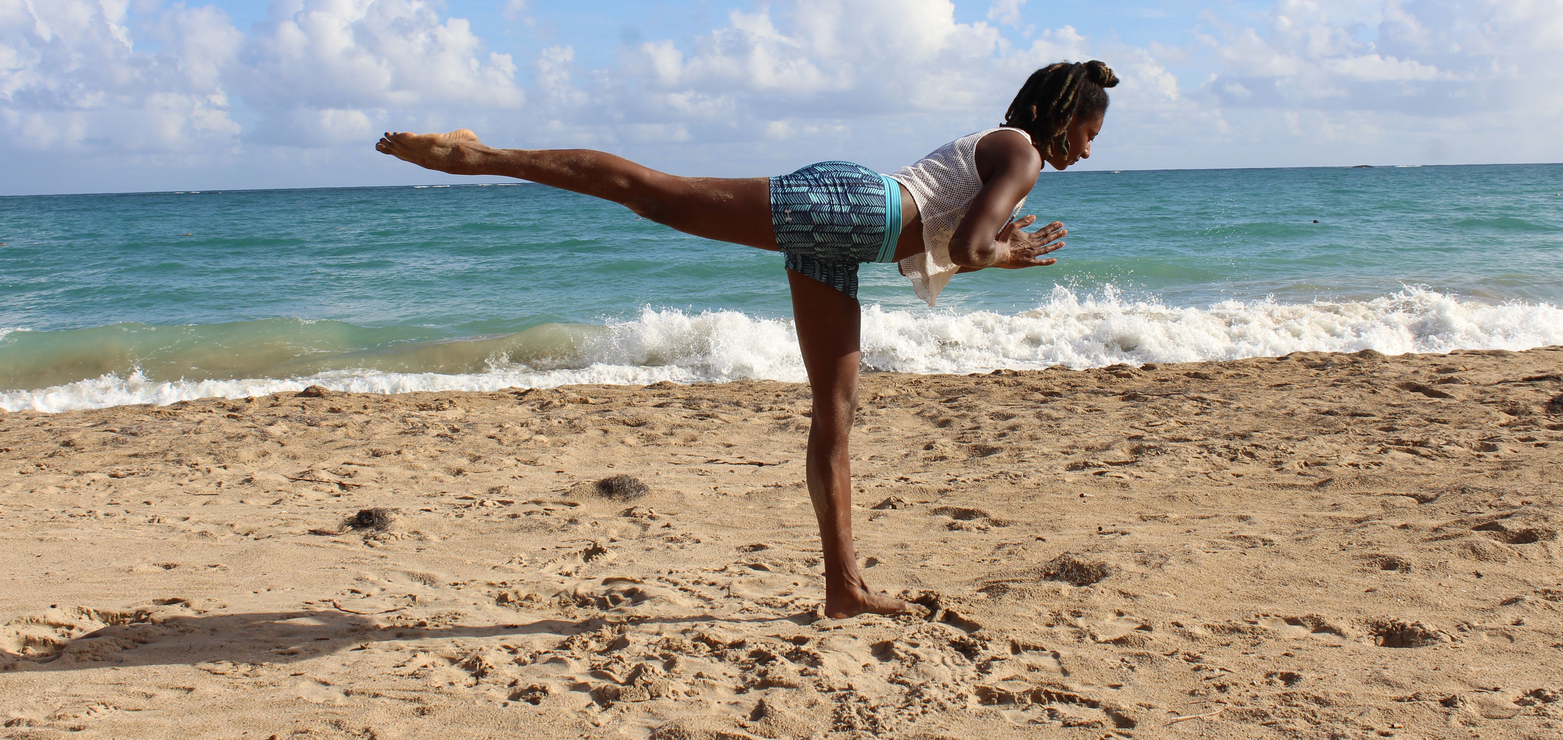 Warrior III yoga pose performed by fitness woman at beach stock photo