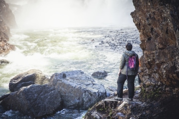 hiker looking at a waterfall