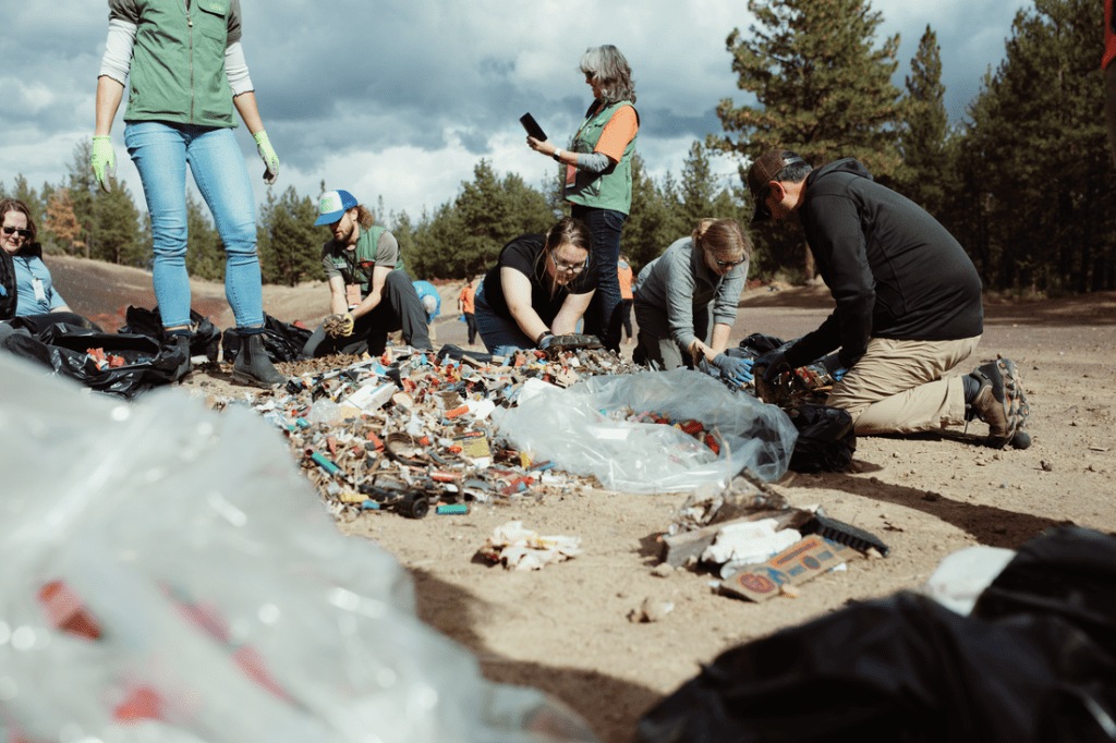 A group of volunteers sort through trash.