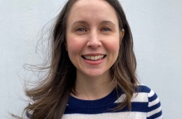 Smiling woman with long brown hair in a striped shirt