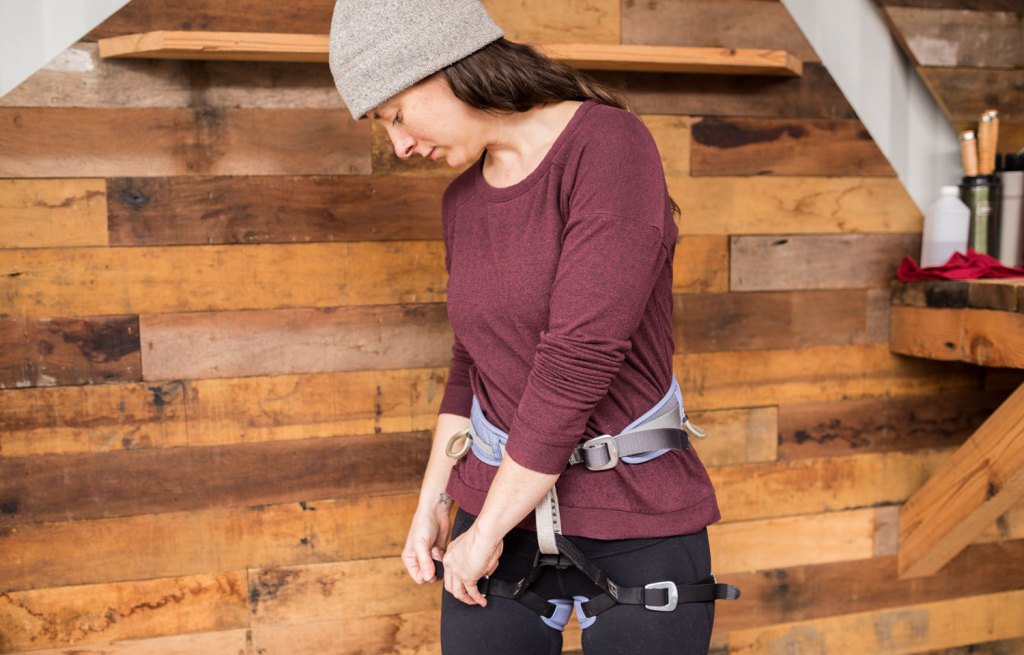 Woman checking climbing harness for safety