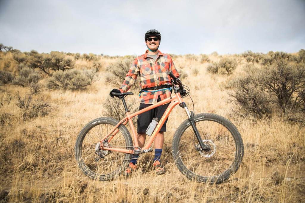 Rider standing behind his bike. 