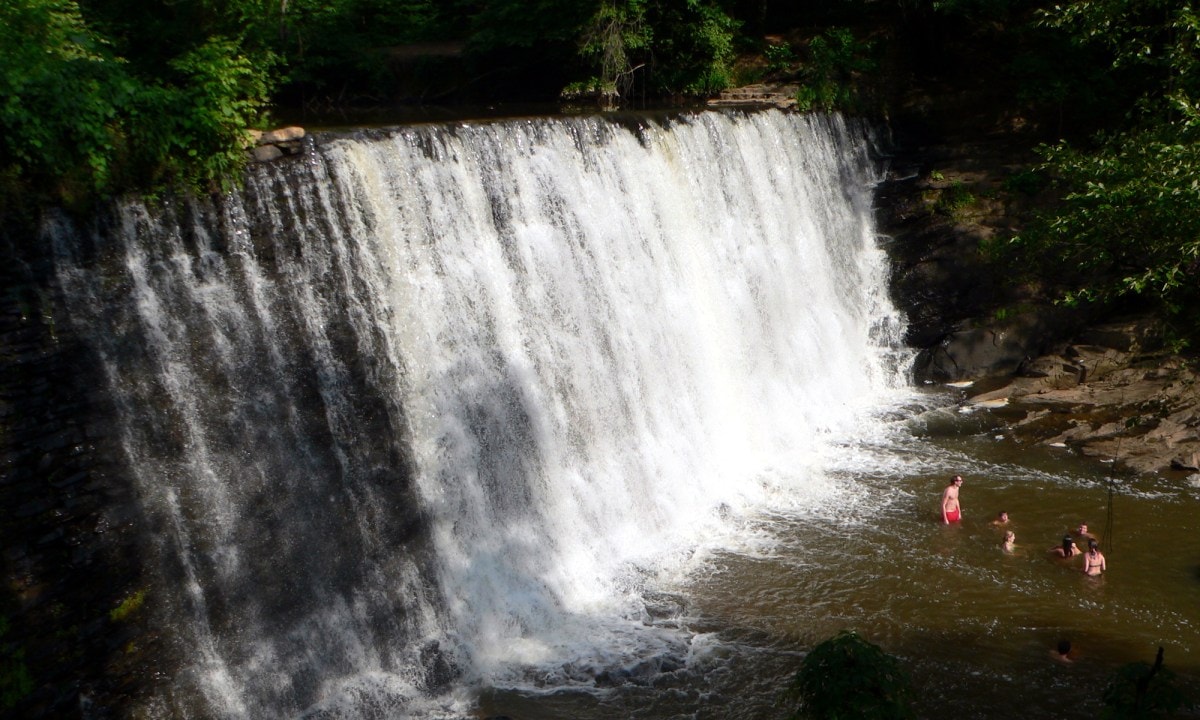 Visitors enjoy wading at the base of Vickery Creek Falls.