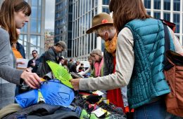 Two people shop at a REI Used Gear Swap stand.