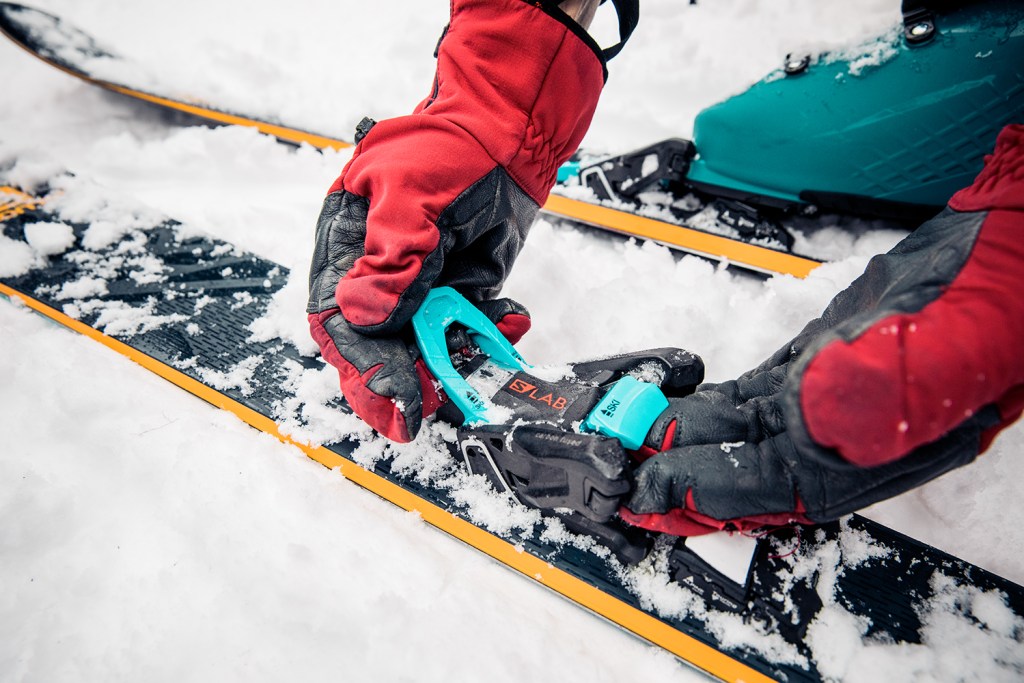 A tester switches the binding from ski mode to hike mode.
