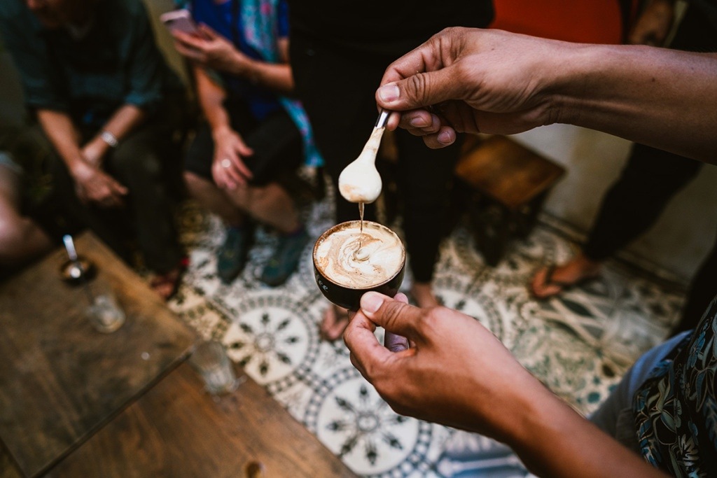 A traveler is served a cup of rich, locally grown coffee.