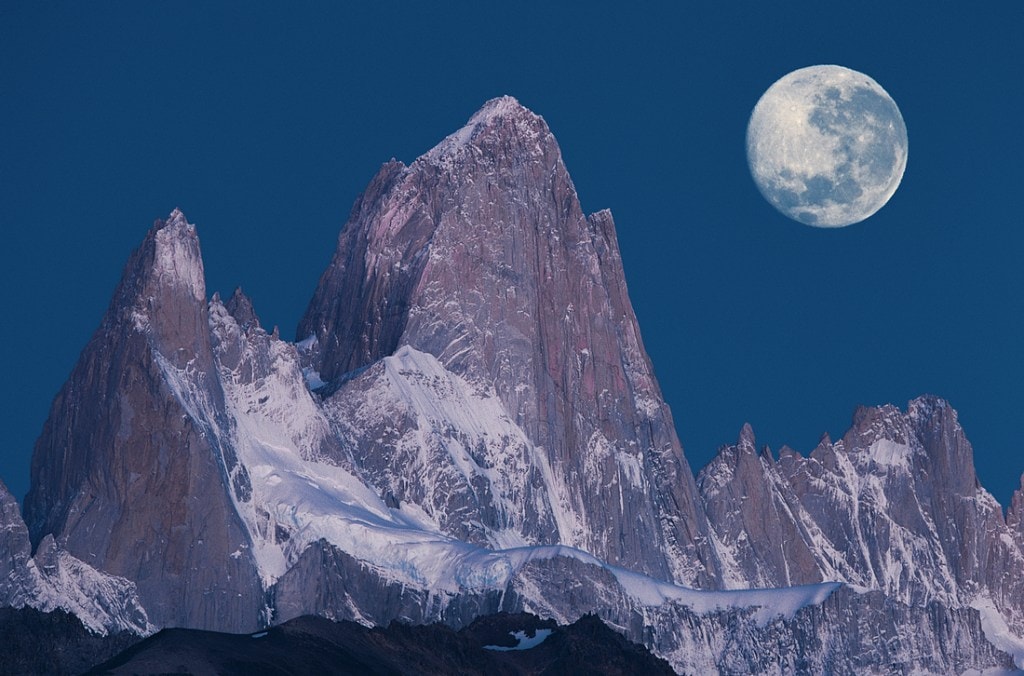 A full moon illuminates a granite spire. 