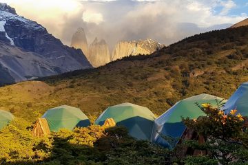 Tents sit in front of jagged spires in Patagonia.