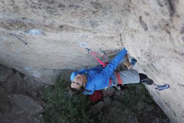 Adaptive climber Craig DeMartino pauses partway up an overhanging route to look for his next holds.