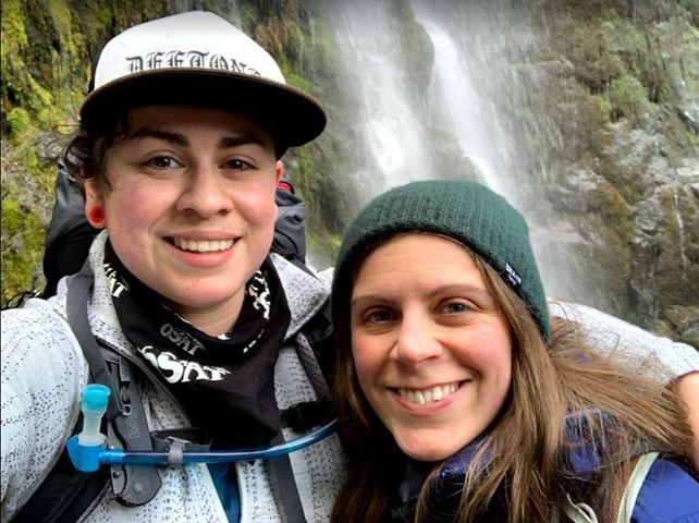 Brisa and her girlfriend taking a selfie in front of a waterfall.