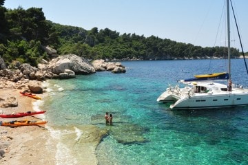 Travelers enjoy the sun, sand and aquamarine sea of a Croatian island.