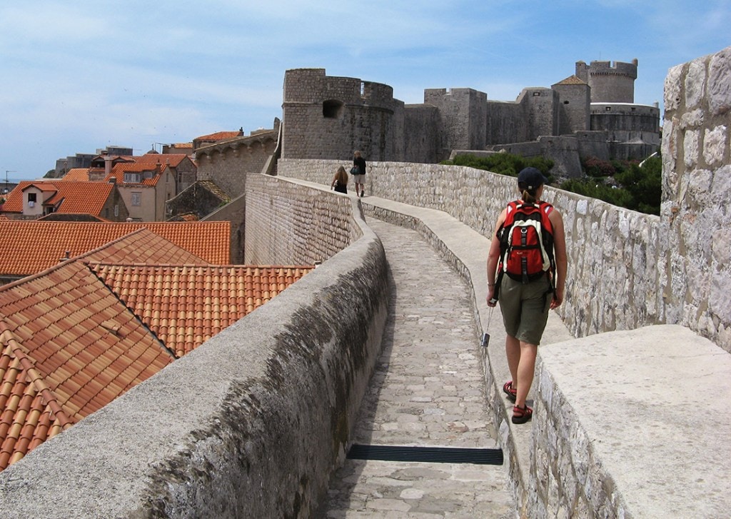 A tourist wanders the walls of Dubrovnik's Old Town.