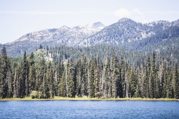 Lake with trees and mountains in the background
