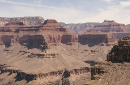 The Grand Canyon's depths are in the foreground, the rock formations behind span as far away into the distance.