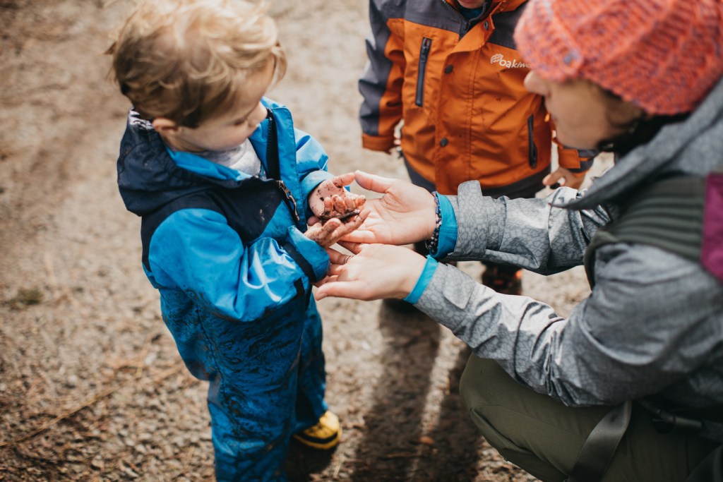 A mother and a child investigate a worm together