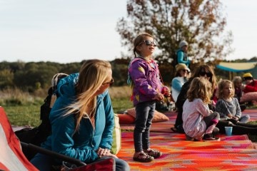 A child staring into the distance with sunglasses on